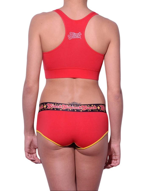 Full length rear view of a model wearing Ginch Gonch red atomic fireballs boyfriend cotton stretch brief with a sports bra.