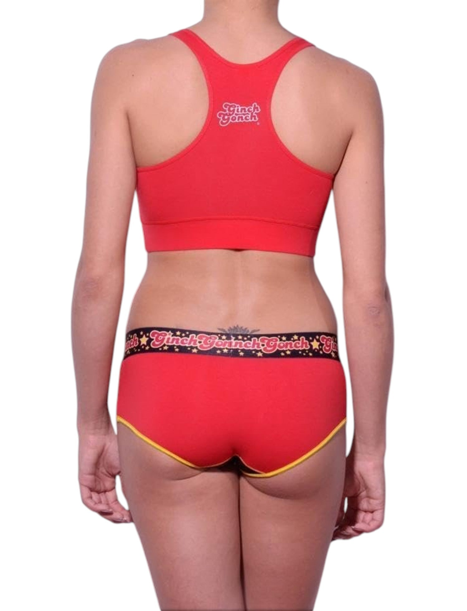 Full length rear view of a model wearing Ginch Gonch red atomic fireballs sports bra cotton stretch top activewear with a white background.
