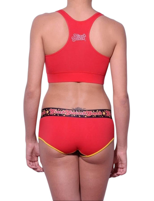 Full length rear view of a model wearing Ginch Gonch red atomic fireballs sports bra cotton stretch top activewear with a white background.

