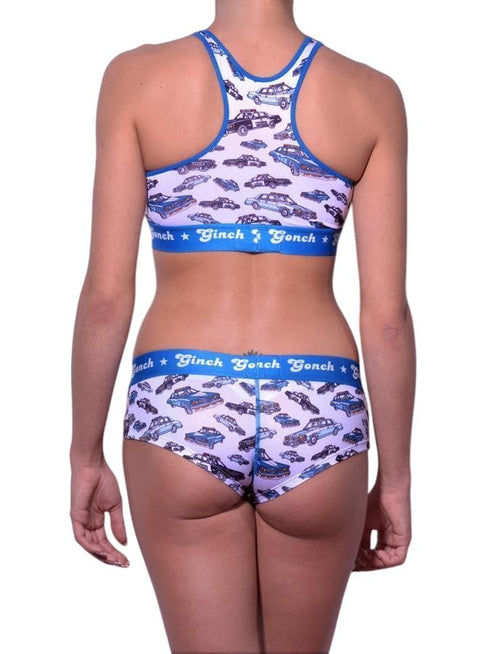 Rear view of a model wearing Ginch Gonch Busted Gogo Briefs with a matching sports bra and an an all-over police car chase print.