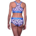 Full length rear view of a model wearing Ginch Gonch Busted Sports Bra with a matching panty brief featuring a vibrant all-over police car chase print.