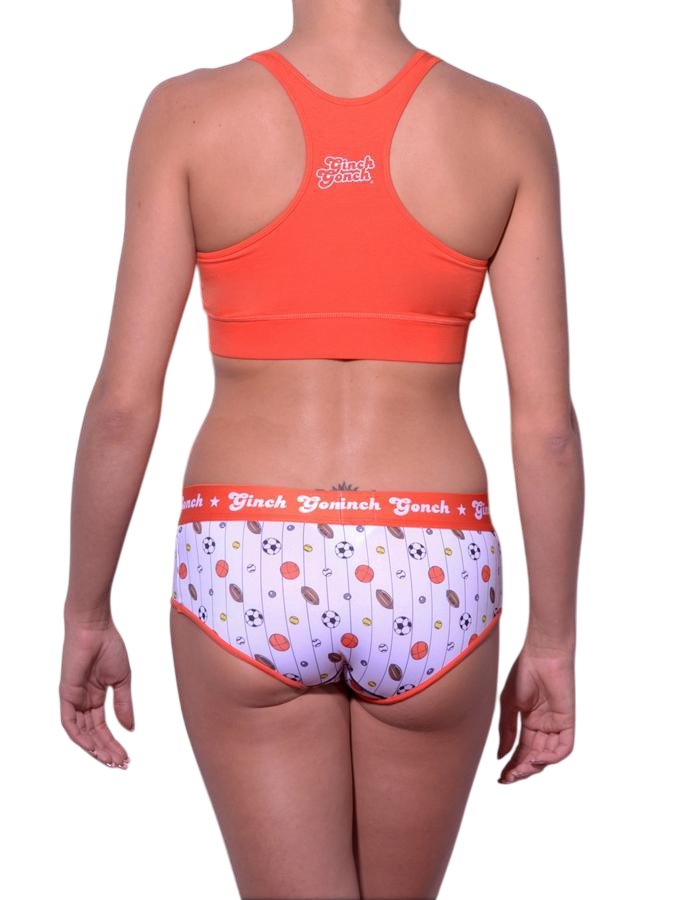 Full length rear view of a model wearing Ginch Gonch sporty print hardball boyfriend cotton stretch brief with an orange sports bra.