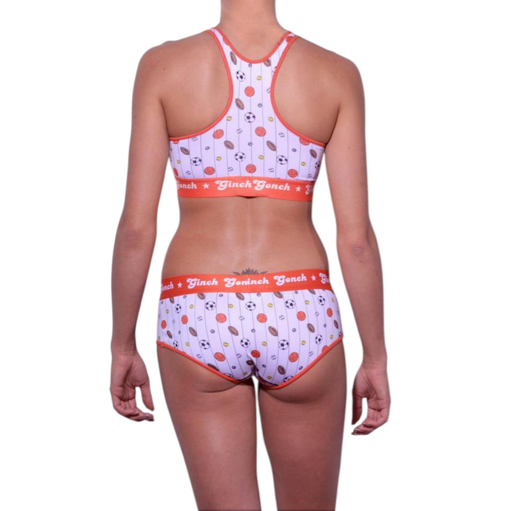 Full length rear view of a model wearing Ginch Gonch Hardball Sports Bra with all-over sports print and matching Gogo briefs, showing the 4-way stretch fit.
