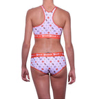 Full length rear view of a model wearing Ginch Gonch Hardball Sports Bra with all-over sports print and matching Gogo briefs, showing the 4-way stretch fit.
