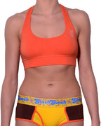 Ginch Gonch sporta bra orange color stretchable cotton worn with a colorblock panty brief by a model with a white background.