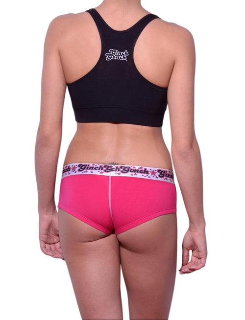 Full length rear view of a model wearing Ginch Gonch pink and white gogo cotton stretch brief with a black sports bra.