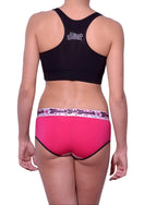 Full length rear view of a model wearing Ginch Gonch white and pink boyfried brief cotton stretch with a black sports bra.
