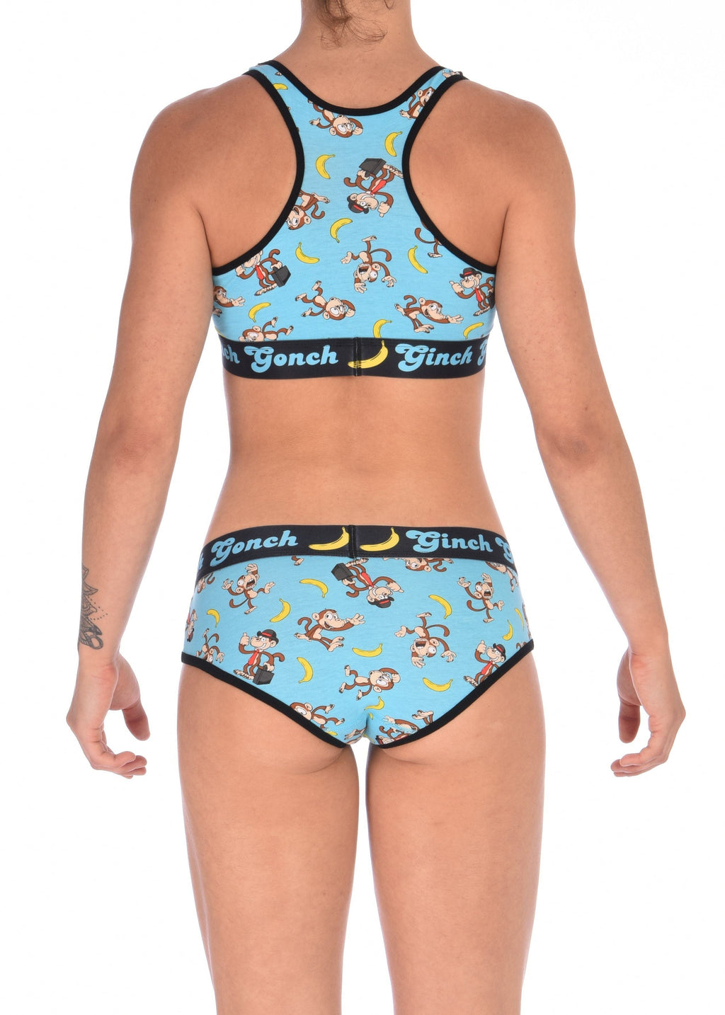Reverse angle of a model wearing Ginch Gonch Monkey Business Women's Boyfriend Briefs, aqua monkey banana print, relaxed cut, anti muffin-top waistband with matching sports bra.