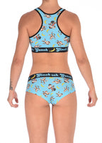From behind view of a model Ginch Gonch Monkey Business Women's Gogo Briefs in aqua monkey banana print, gogo cut, anti muffin-top waistband, model with matching sports bra.