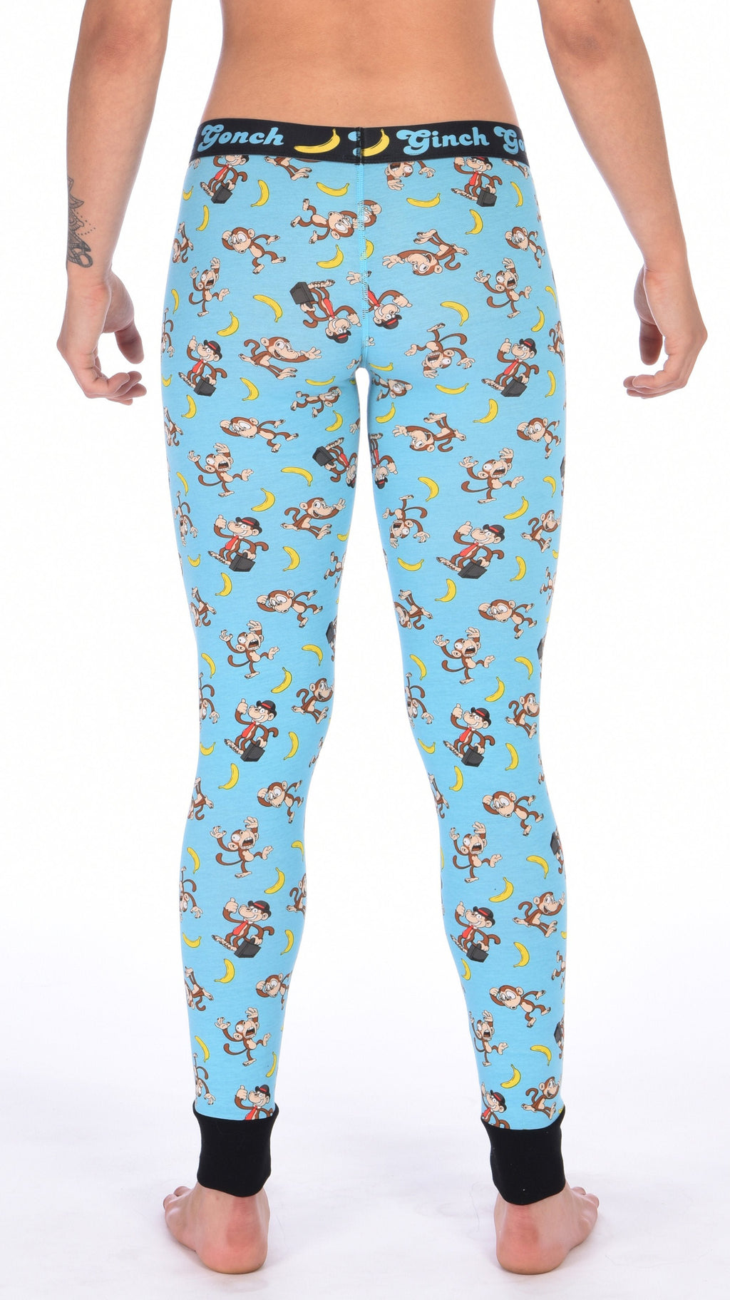 Rear view of a model wearing Ginch Gonch Monkey Business Women's Leggings, aqua blue monkey banana print full-length stretch cotton fit.