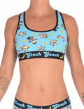 Ginch Gonch Monkey Business Women's Sports Bra, aqua blue with black underband, all-over monkey banana print, 4-way stretch cotton, waist-up on model.