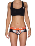 Ginch Gonch Rock Me Gogo Women's Briefs in black with orange waistband, skull and guitar print, cotton stretch underwear and a black sports bra worn by a model.