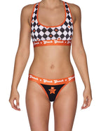 Ginch Gonch Rock Me Women's Thong, black with orange waistband and trim, skull guitar print paired by a aports bra worn by model.