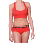 Ginch Gonch gogo brief red color stretchable cotton worn with a sports bra by a model with a white background.