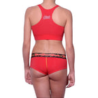 Full length rear view of a model wearing Ginch Gonch red atomic fireballs gogo cotton stretch brief with a sports bra.