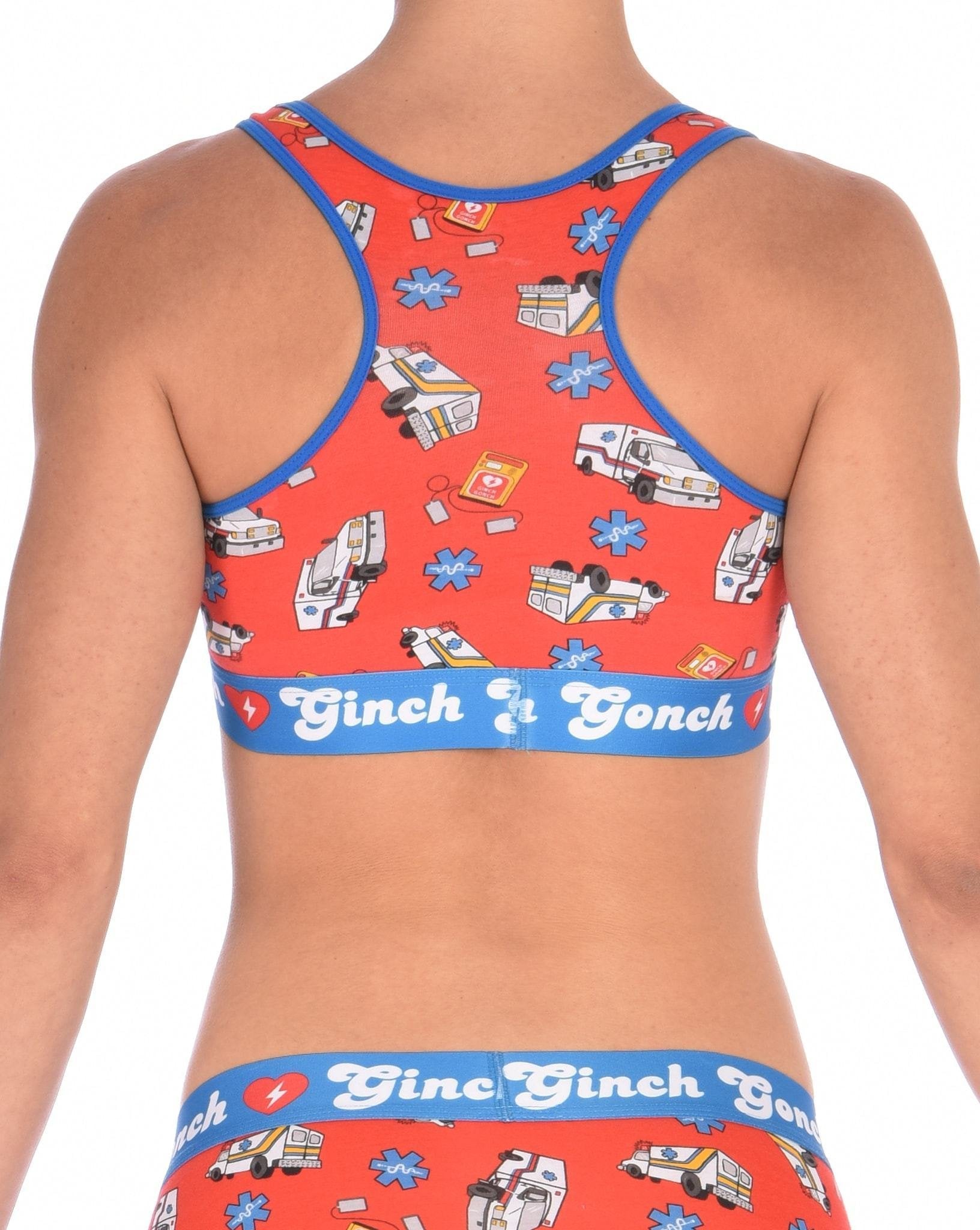 Rear view of a model wearing a orange  Ginch Gonch GG EMT sports bra showing racerback design and medical print stretch cotton.