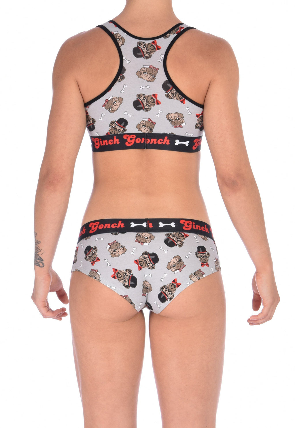 Seen from behind of a model wearing of Ginch Gonch Pug Life grey gogo briefs showing anti-muffin waistband and pug print stretch cotton paired with a similar sports bra.