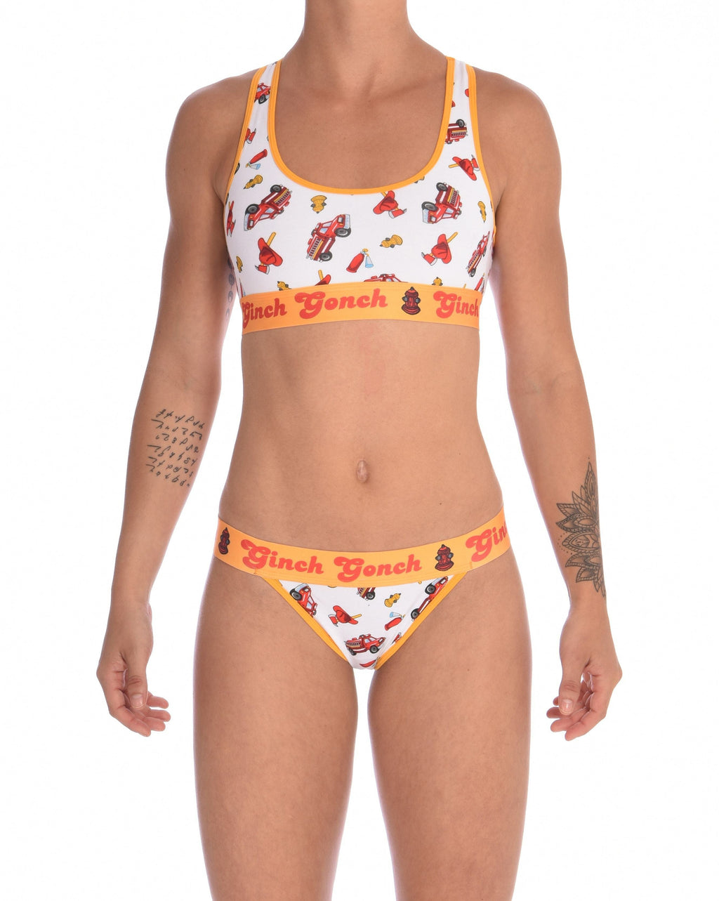 Full view of a model wearing a Ginch Gonch GG Fire Fighters thong showing minimal coverage and firefighter print stretch cotton paired with a matching sports bra.