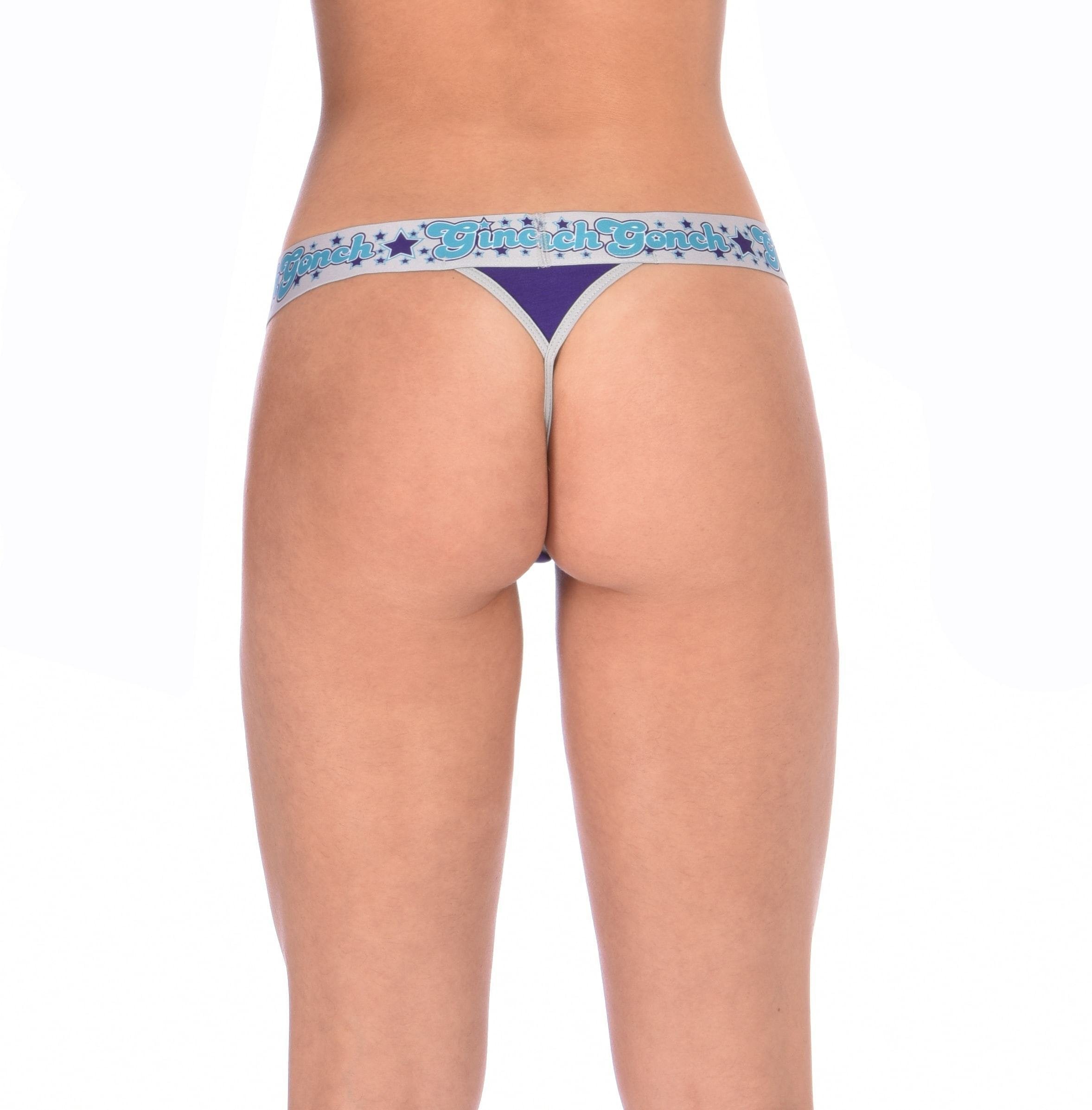 Rear view detail of Ginch Gonch Purple Haze thong showing minimal coverage and bold color block stretch cotton worn by a model.