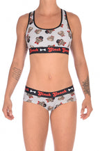 Front view of a model wearing a Ginch Gonch Pug Life grey gogo briefs showing anti-muffin waistband and pug print stretch cotton with matching printed sports bra.