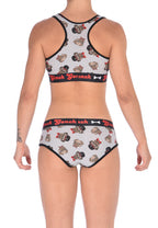 From the back view of a model wearing Ginch Gonch Pug Life boyfriend briefs showing full seat coverage and pug print stretch cotton fabric with matching sports bra.