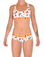 Full oufit view of a model wearingGinch Gonch GG Fire Fighters gogo briefs showing anti-muffin waistband and firefighter print cotton with amatching sports bra.