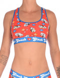 Ginch Gonch GG EMT Women's sports bra in fun orange medical-themed print, 4-way stretch cotton racerback bralette worn by a model.