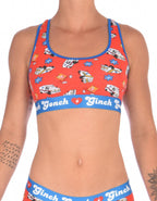 Ginch Gonch GG EMT Women's sports bra in fun orange medical-themed print, 4-way stretch cotton racerback bralette worn by a model.