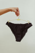 Paulette & Maria Black organic cotton frilly panties, front view on a white background.