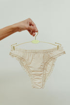 Paulette & Maria Natural dye-free organic cotton frilly panties, front view on a white background.