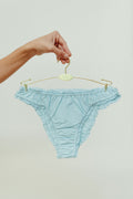 Paulette & Maria Pastel Blue organic cotton frilly panties, front view on a white background.