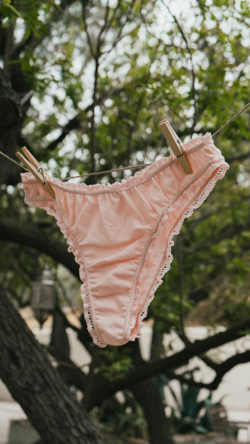 Paulette & Maria Powder Pink organic cotton panties, clothesline outdoor lifestyle view.