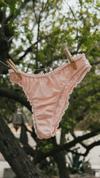 Paulette & Maria Powder Pink organic cotton panties, clothesline outdoor lifestyle view.
