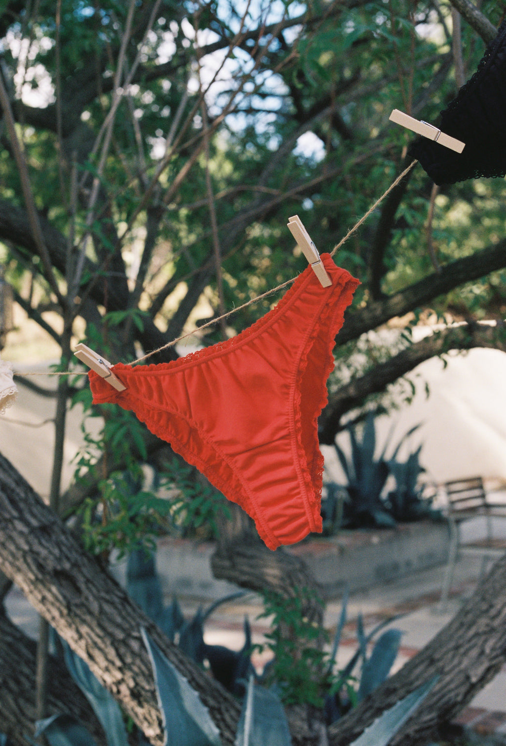 Paulette & Maria Red organic cotton panties, eco-friendly laundry lifestyle shot.